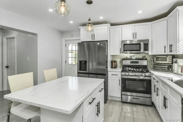 a kitchen with stainless steel appliances a stove a sink island and a refrigerator