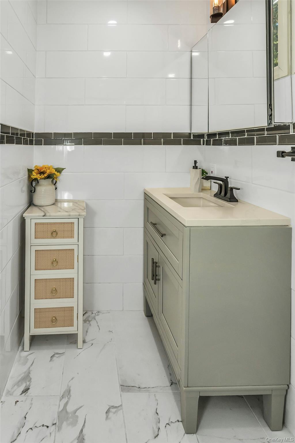 42 13th Street Locust Valley, NY 11560 - Photo 17 of 34 Half bath with vanity, tile walls, and light marble finish floors