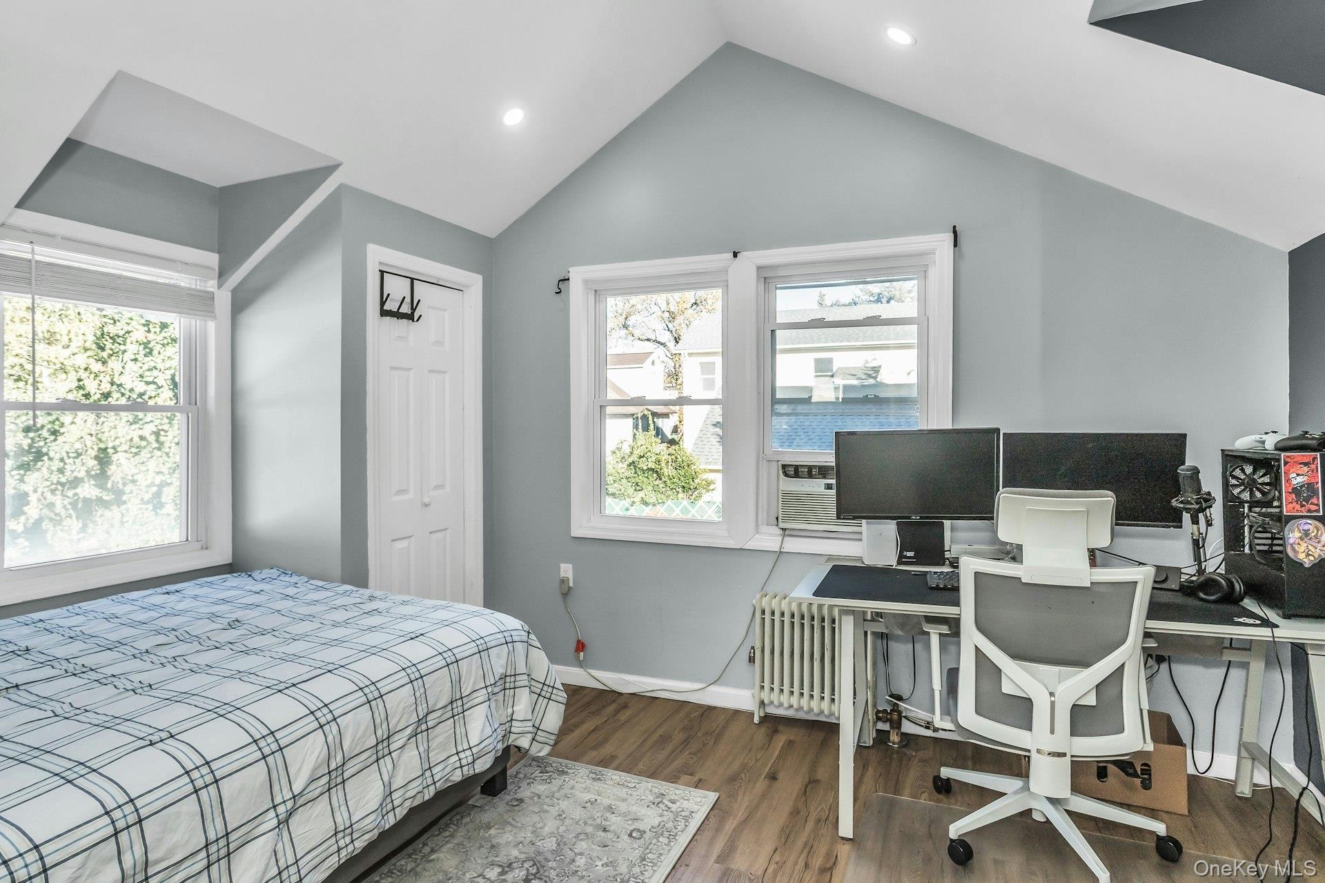 42 13th Street Locust Valley, NY 11560 - Photo 20 of 34 Bedroom with wood finished floors, multiple windows, an office area, a closet, and vaulted ceiling