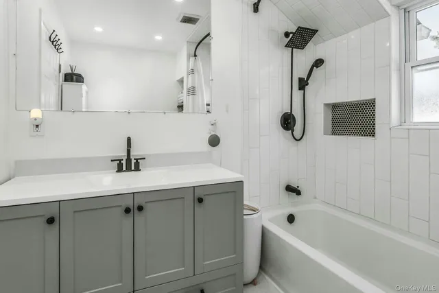 a bathroom with a sink a toilet a mirror and shower