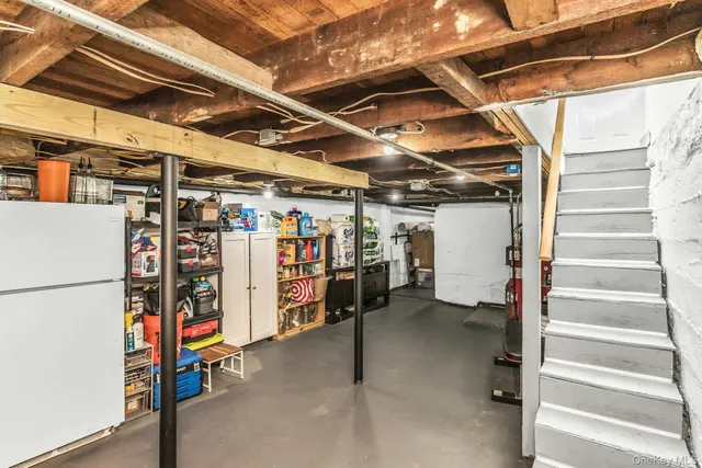 a view of storage and utility room with refrigerator and racks