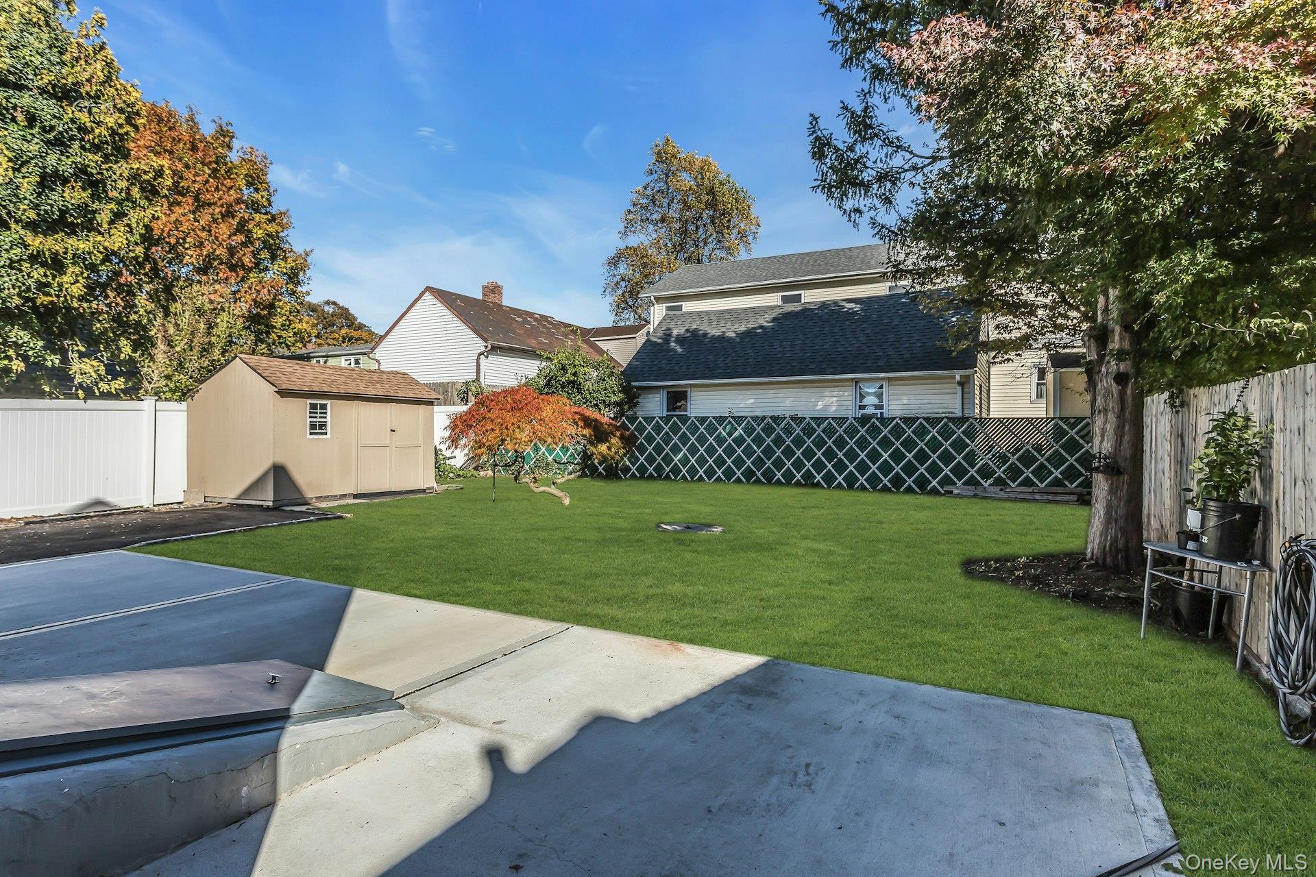 42 13th Street Locust Valley, NY 11560 - Photo 28 of 34 Fenced backyard featuring a storage unit and a patio area