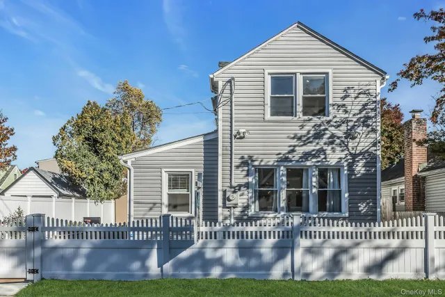 a front view of a house with a yard and outdoor seating