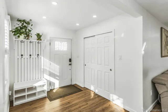 a view of a hallway with wooden floor and closet area