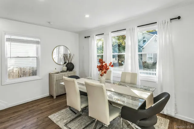 a dining room with wooden floor a glass table and chairs