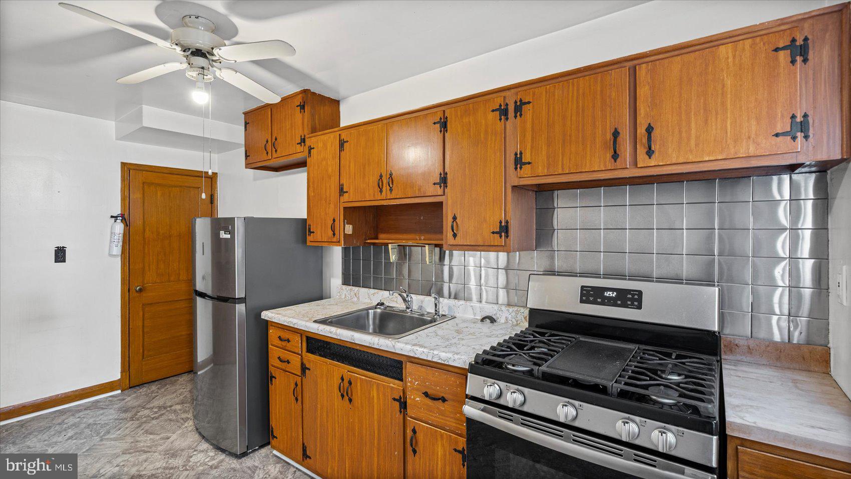1805 Crestview Road Baltimore, MD 21239 - Photo 13 of 39 a kitchen with stainless steel appliances granite countertop a stove a refrigerator and a cabinets