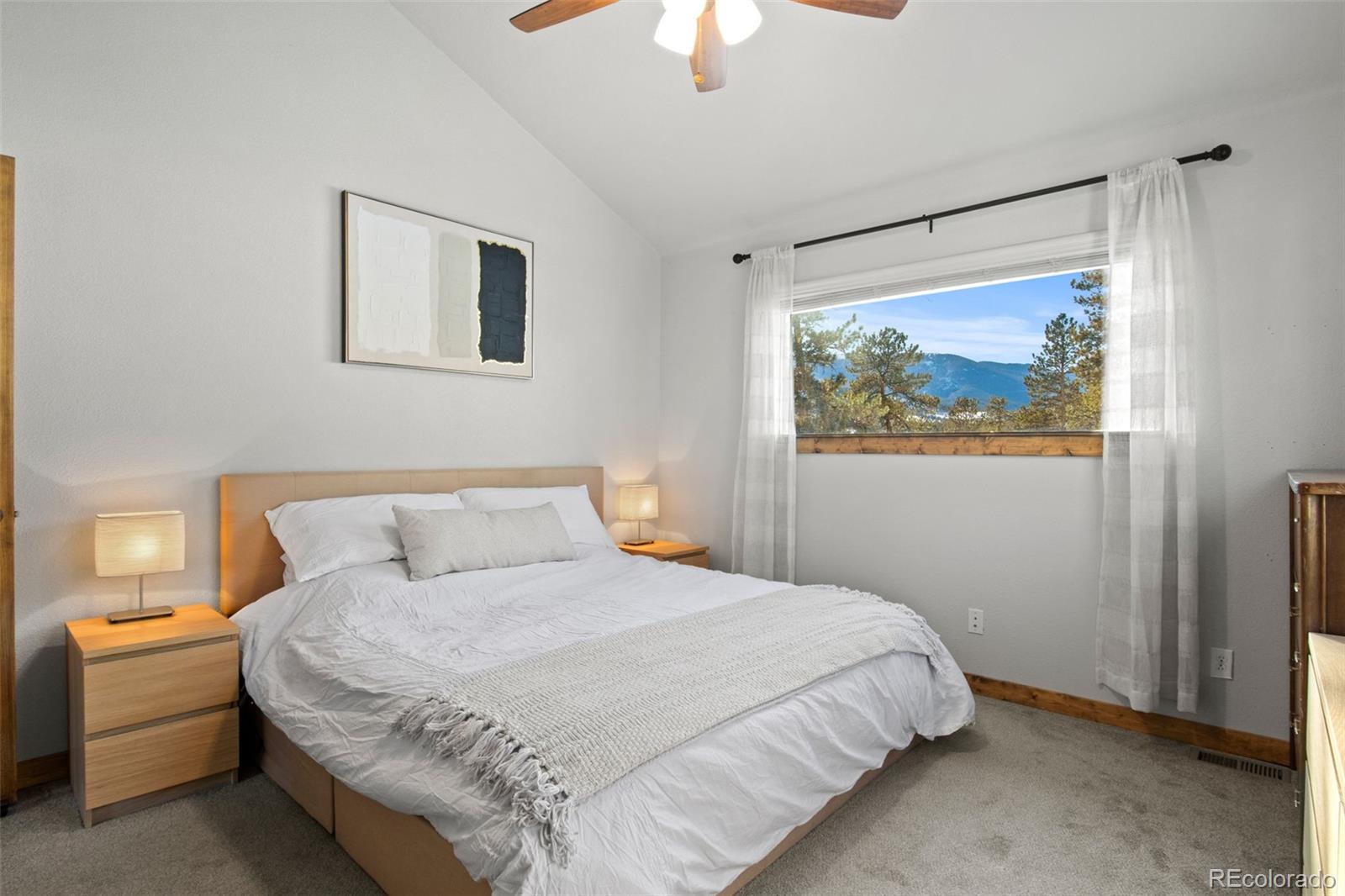 200 Virginia Road Bailey, CO 80421 - Photo 19 of 49 a bedroom with a bed and a chandelier