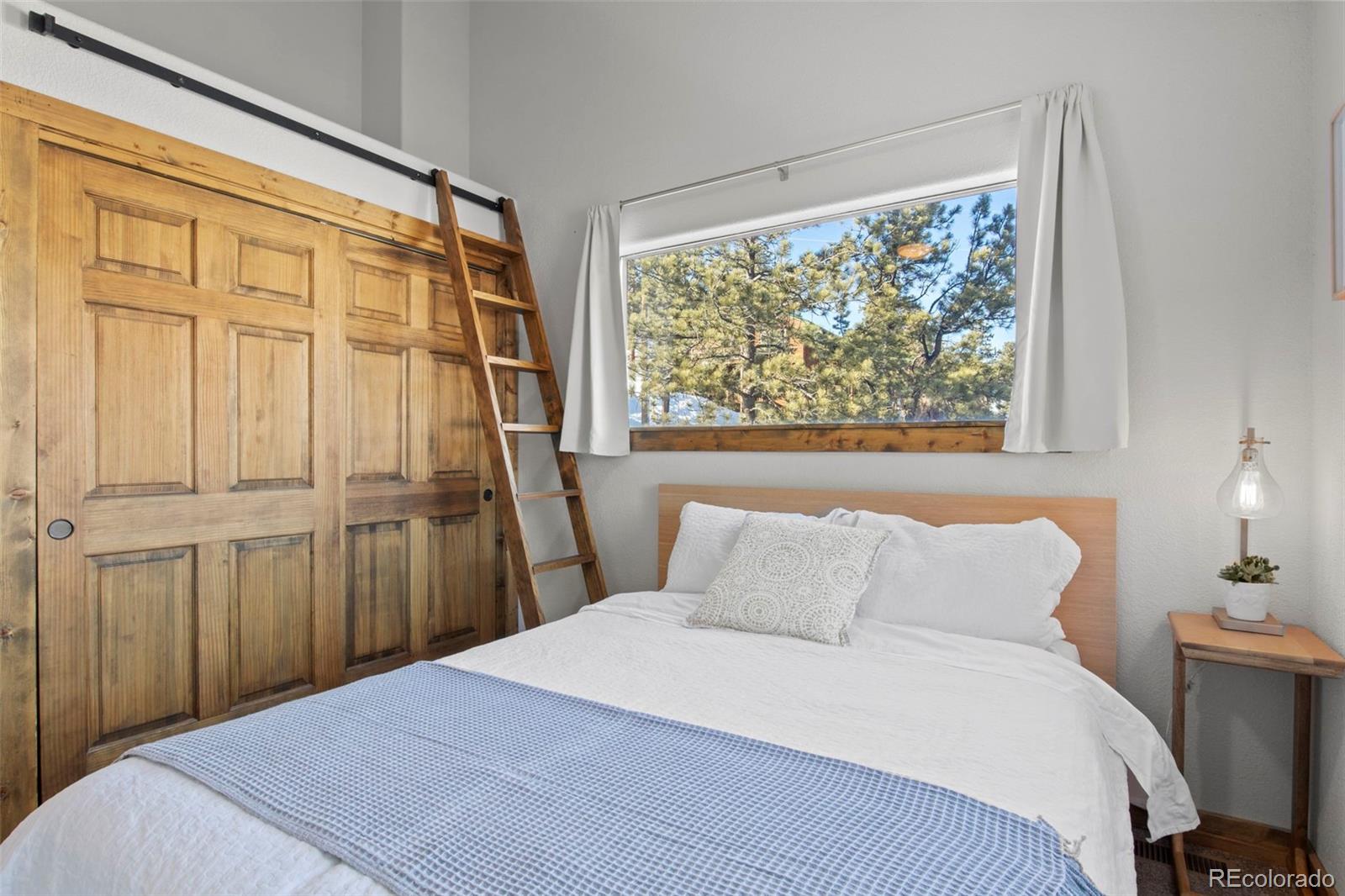 200 Virginia Road Bailey, CO 80421 - Photo 25 of 49 a bedroom with a large bed and a window