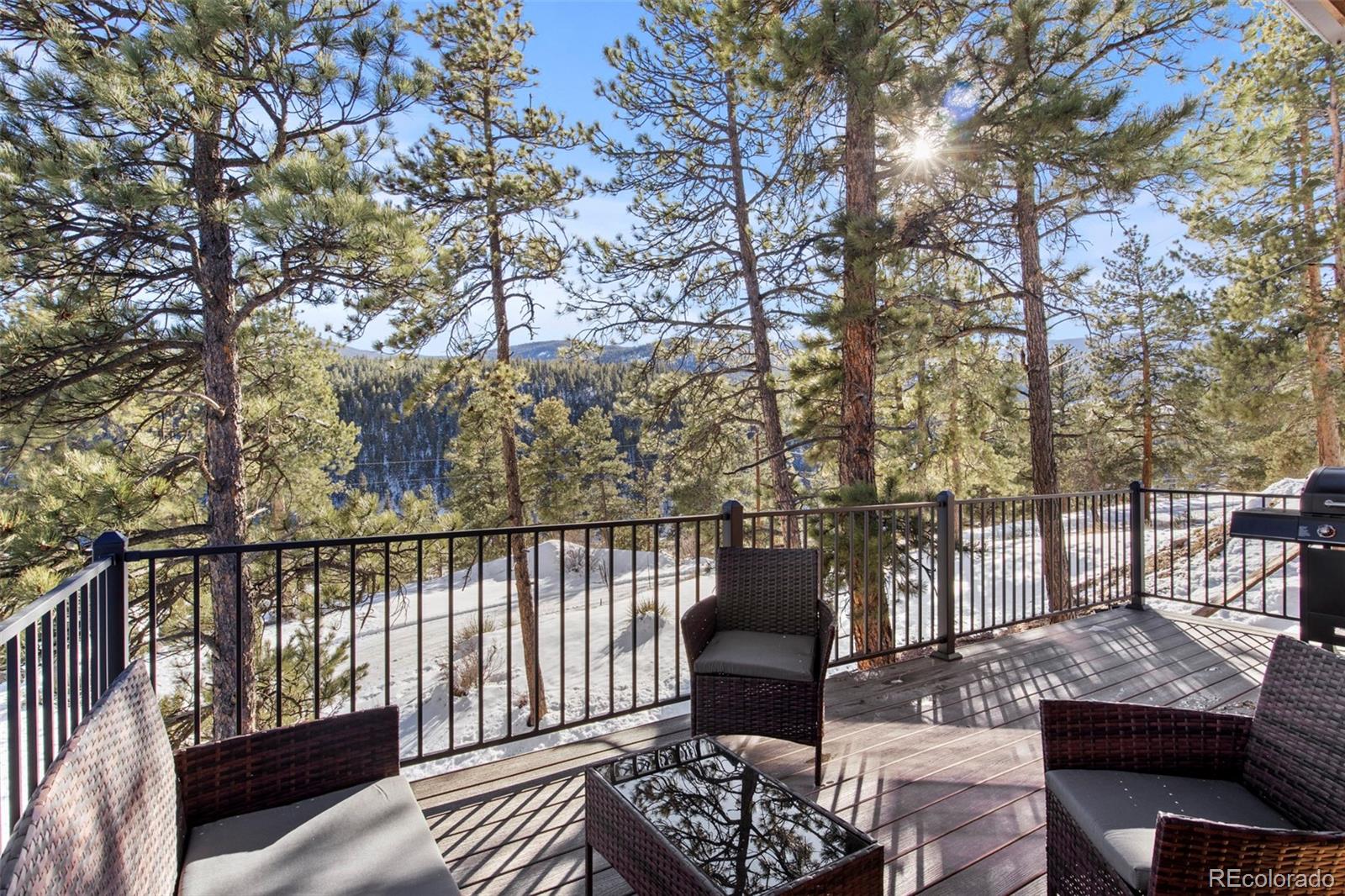 200 Virginia Road Bailey, CO 80421 - Photo 37 of 49 a balcony with wooden floor table and chairs