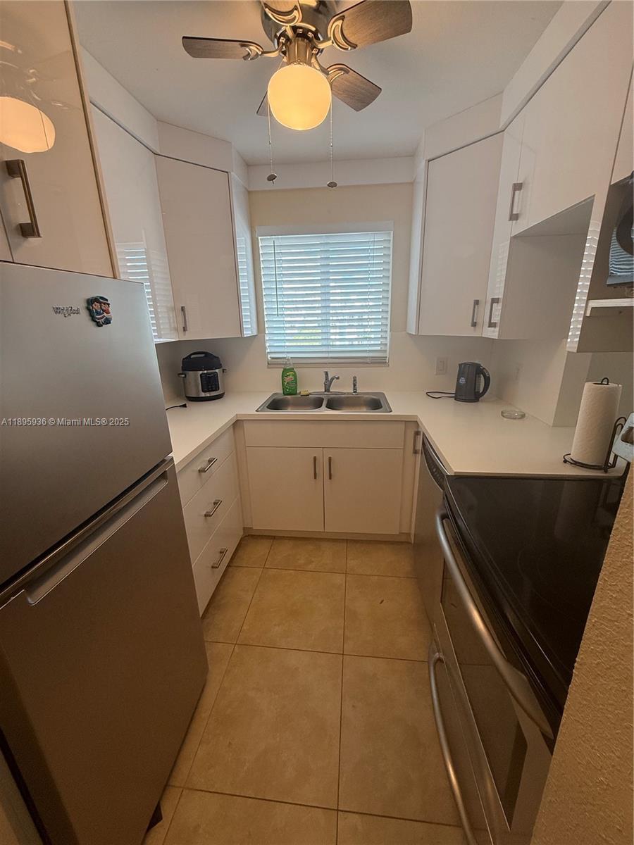 2860 Northeast 14th Street Causeway, Unit 406D Pompano Beach, FL 33062 - Photo 1 of 25 a kitchen with a sink appliances and cabinets