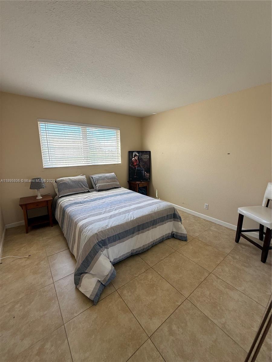 2860 Northeast 14th Street Causeway, Unit 406D Pompano Beach, FL 33062 - Photo 11 of 25 a bedroom with a bed and a desk