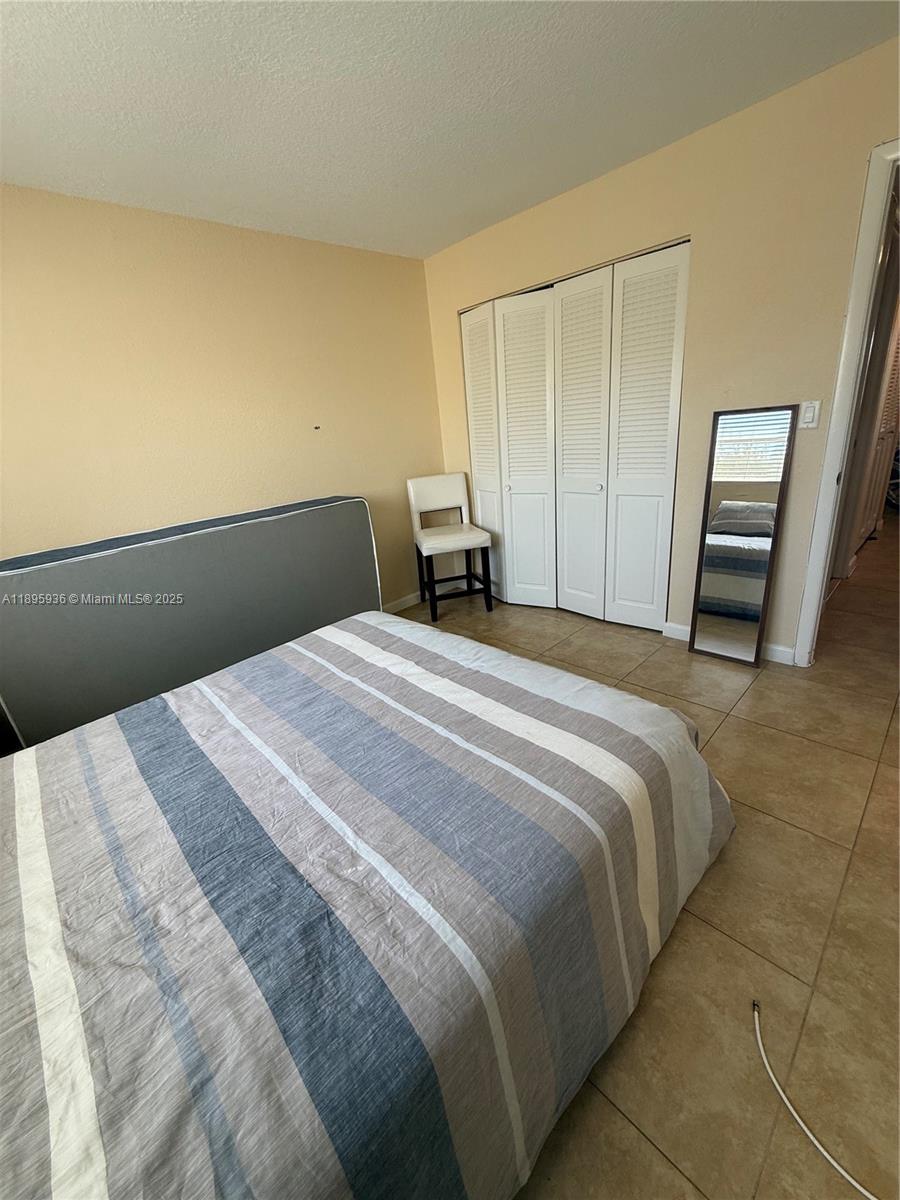 2860 Northeast 14th Street Causeway, Unit 406D Pompano Beach, FL 33062 - Photo 12 of 25 a bedroom with a bed and a window