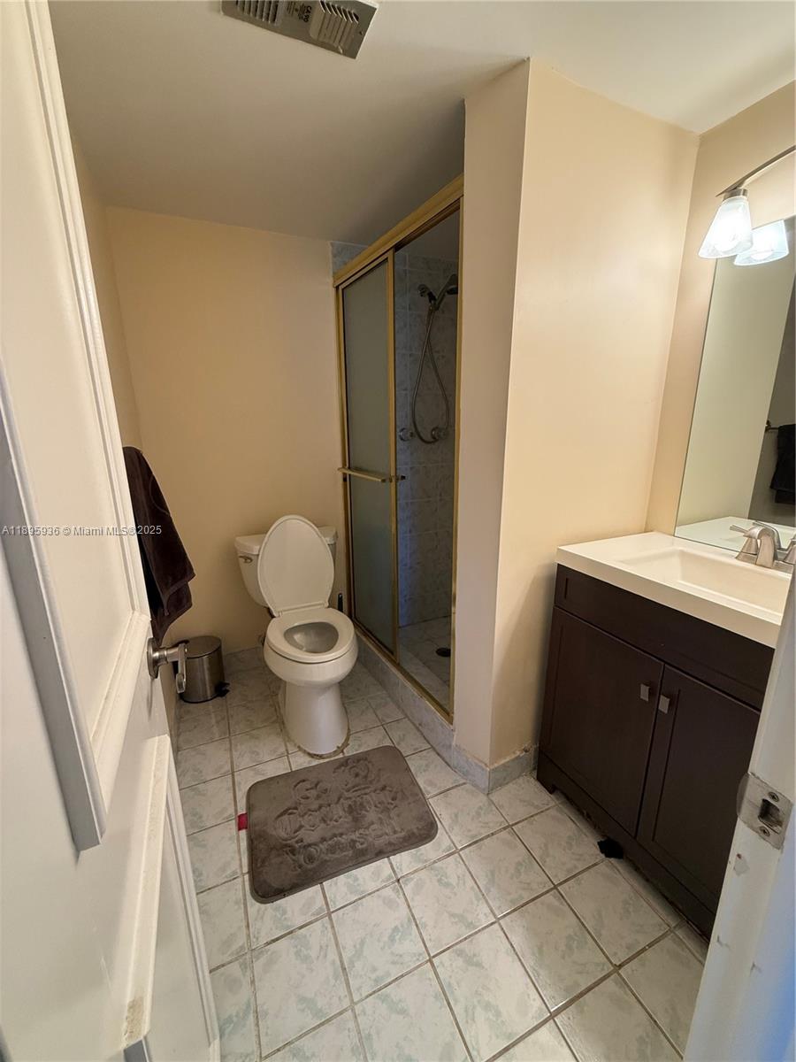 2860 Northeast 14th Street Causeway, Unit 406D Pompano Beach, FL 33062 - Photo 16 of 25 a bathroom with a sink a toilet a mirror and vanity