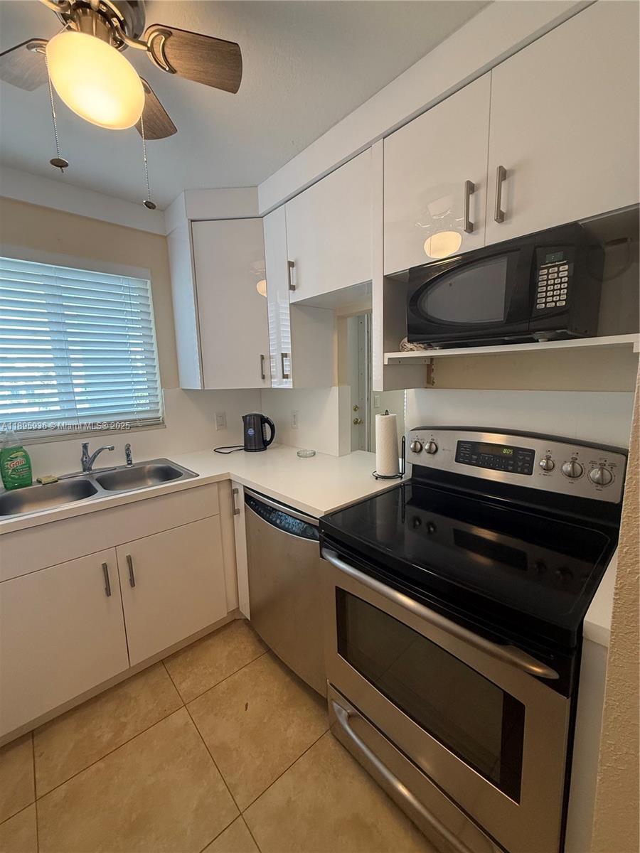2860 Northeast 14th Street Causeway, Unit 406D Pompano Beach, FL 33062 - Photo 3 of 25 a kitchen with a stove and a sink