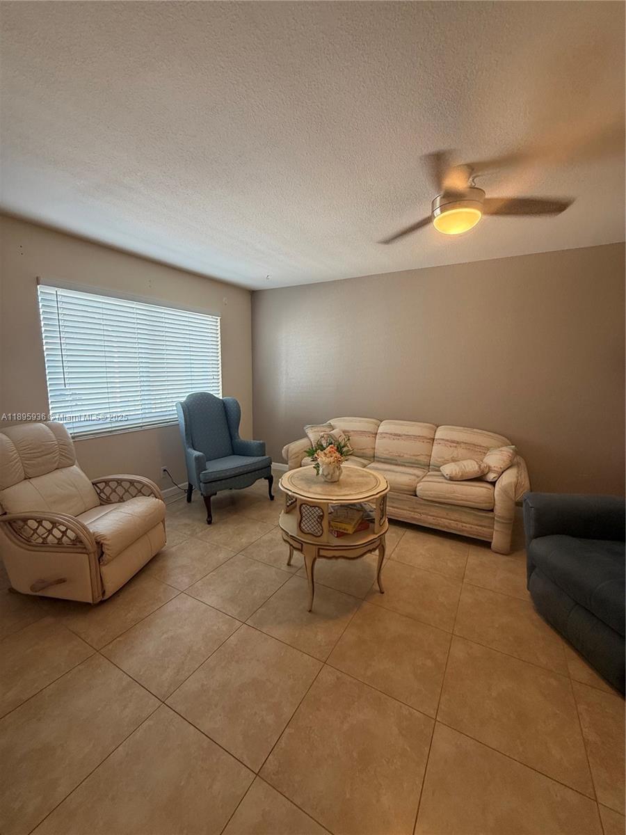 2860 Northeast 14th Street Causeway, Unit 406D Pompano Beach, FL 33062 - Photo 9 of 25 a living room with furniture and a lamp