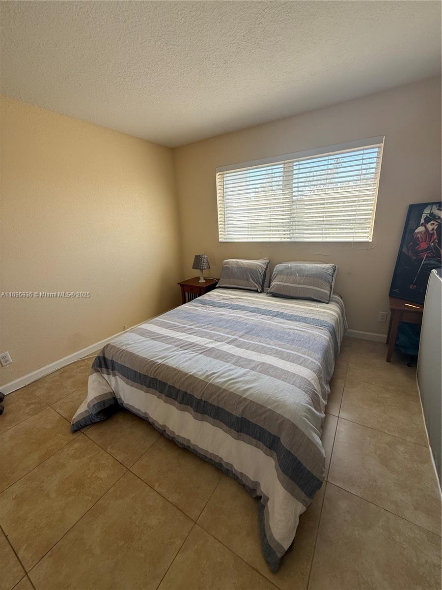 2860 Northeast 14th Street Causeway, Unit 406D Pompano Beach, FL 33062 - Photo 10 of 25 a bedroom with a bed and window