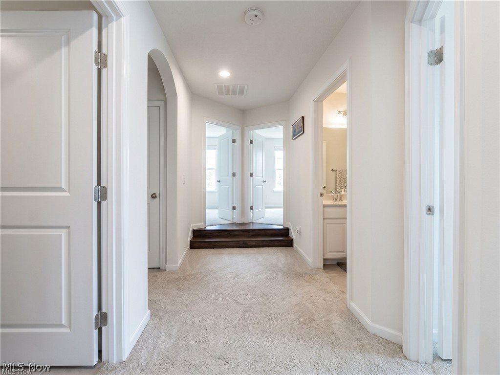 4509 Millbrook Way Akron, OH 44321 - Photo 16 of 27 Hallway featuring neutral-toned carpet, white trim, and white doors