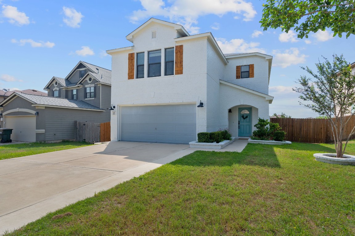 a front view of a house with a yard and garage