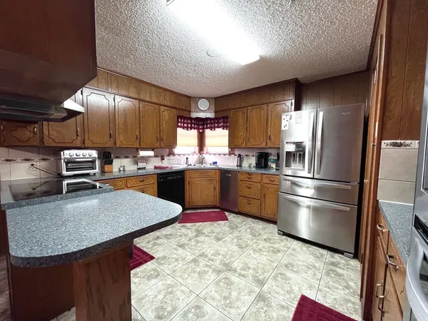 a kitchen with stainless steel appliances granite countertop a sink window and refrigerator