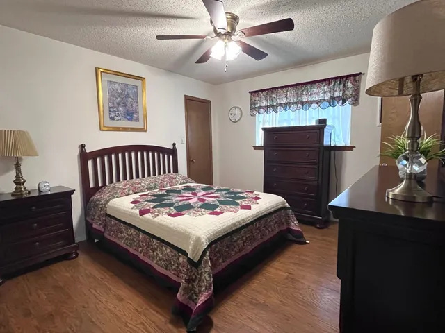 a bedroom with a bed table and dresser
