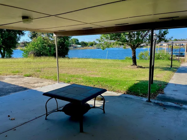 a view of a patio with table and chairs under an umbrella
