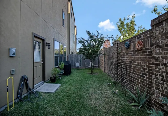 a view of backyard with potted plants and wooden fence