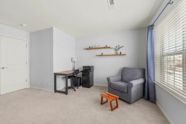 a view of a livingroom with workspace and a window