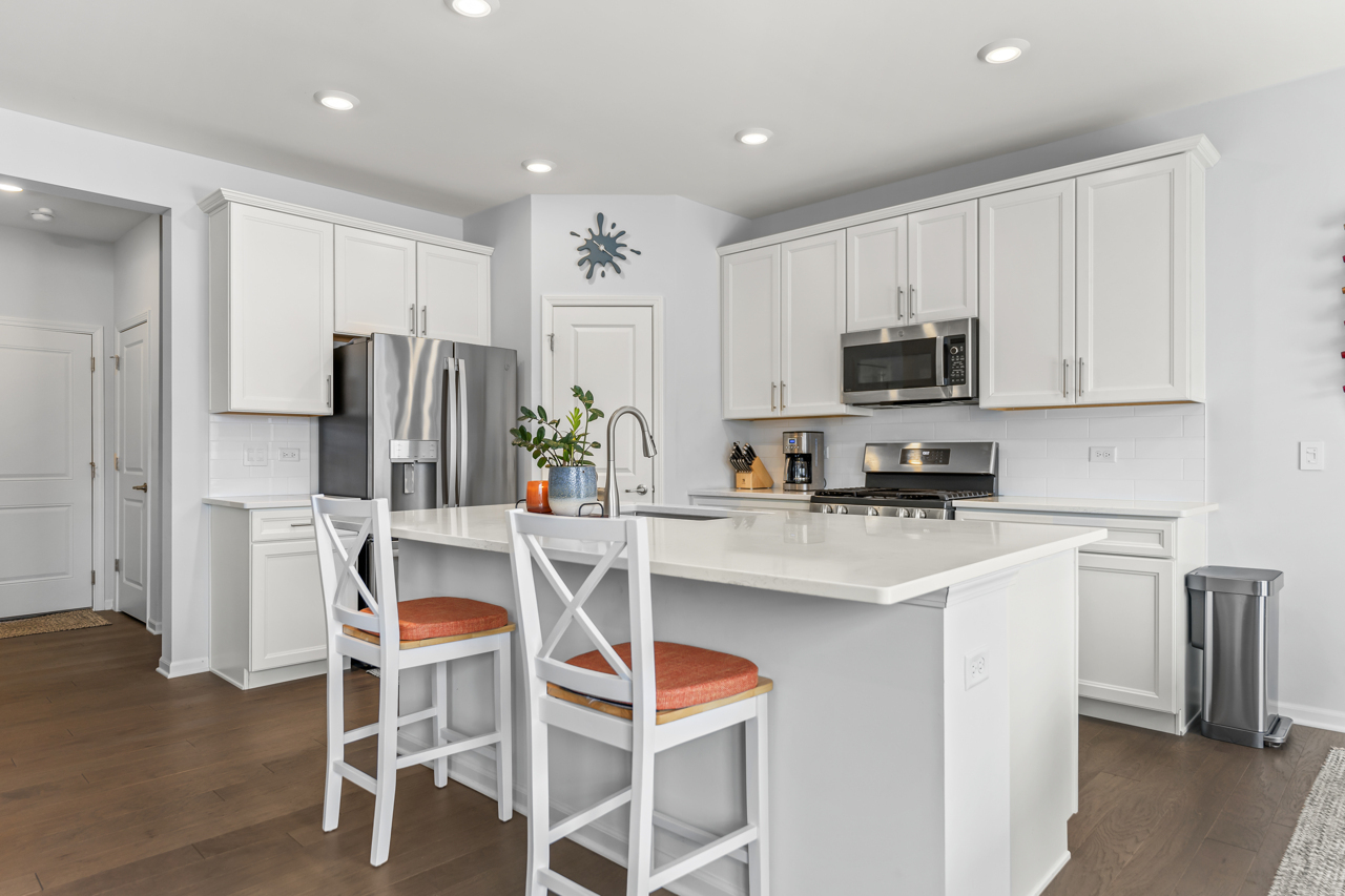 1241 Draper Road McHenry, IL 60050 - Photo 6 of 27 a kitchen with stainless steel appliances a refrigerator stove microwave and white cabinets