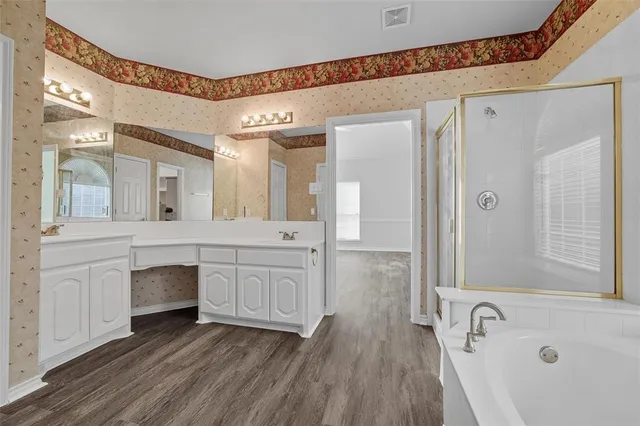 a spacious bathroom with a granite countertop sink mirror and a bathtub