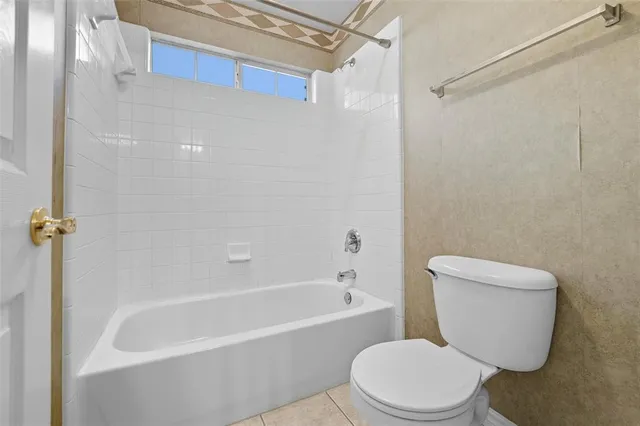 a white toilet and tub sitting next to a bathroom sink