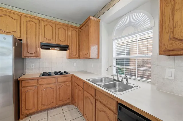 a kitchen with stainless steel appliances a sink a stove and white cabinets