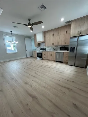 a large kitchen with stainless steel appliances granite countertop a stove a sink and a refrigerator