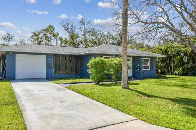 front view of a house with a yard and an trees