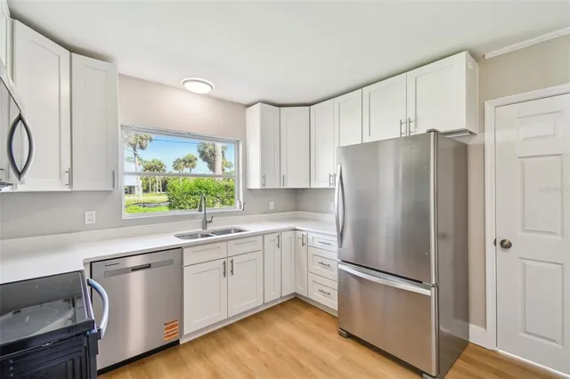 a kitchen with a refrigerator sink and cabinets