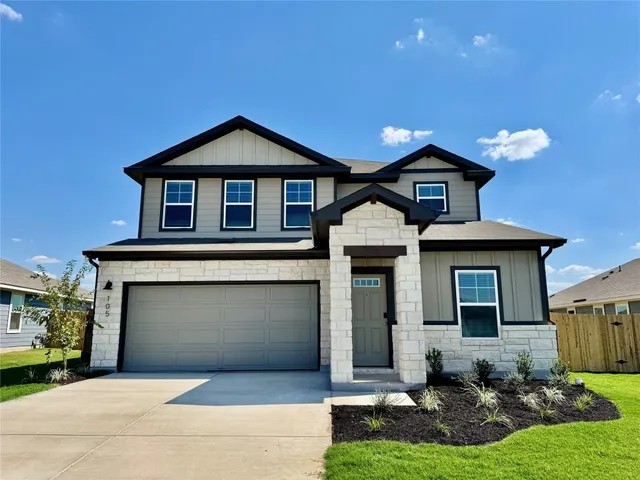 a front view of a house with yard and garage