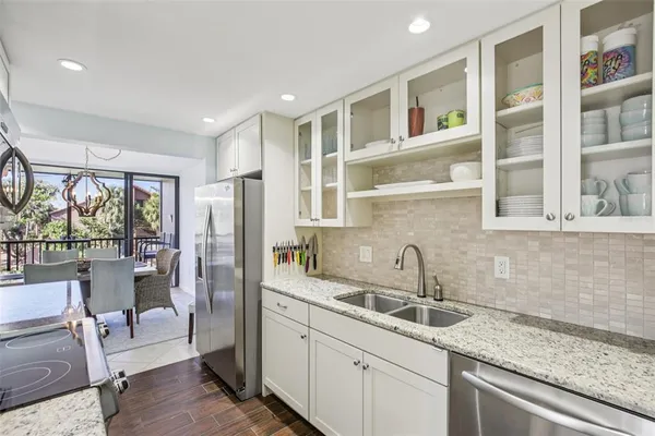 a kitchen with a sink wooden floor and glass door