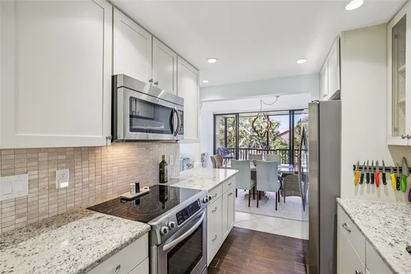 a kitchen with stainless steel appliances granite countertop a sink stove and cabinets