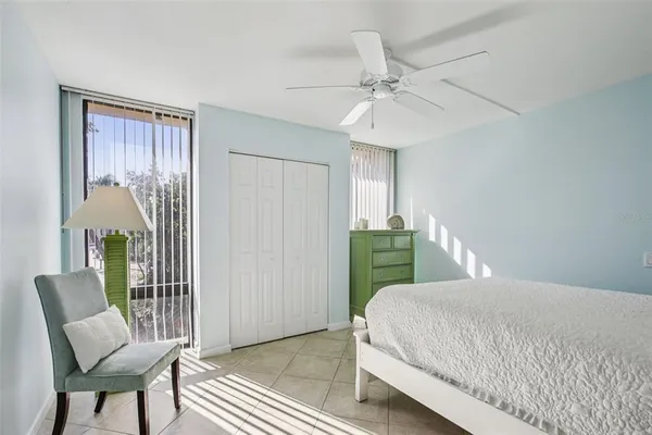 a bedroom with a bed mirror and clock on wall