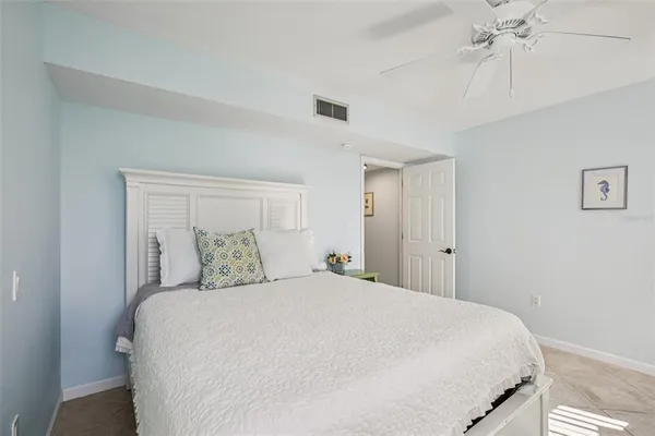 a bedroom with a large bed and a chandelier