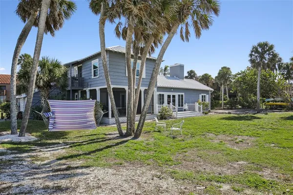 a view of a house with a small yard and palm trees