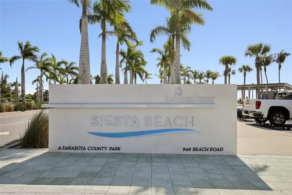 a view of a street with a cars parked and small yard