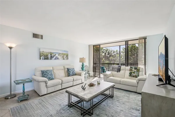 a living room with furniture a large window and a flat screen tv