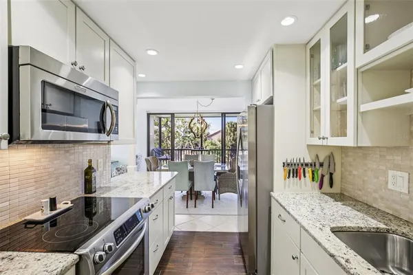 a kitchen with stainless steel appliances granite countertop a sink stove and microwave