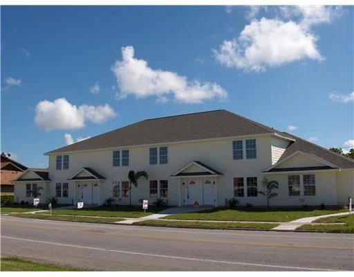 a view of a big house in middle of the road