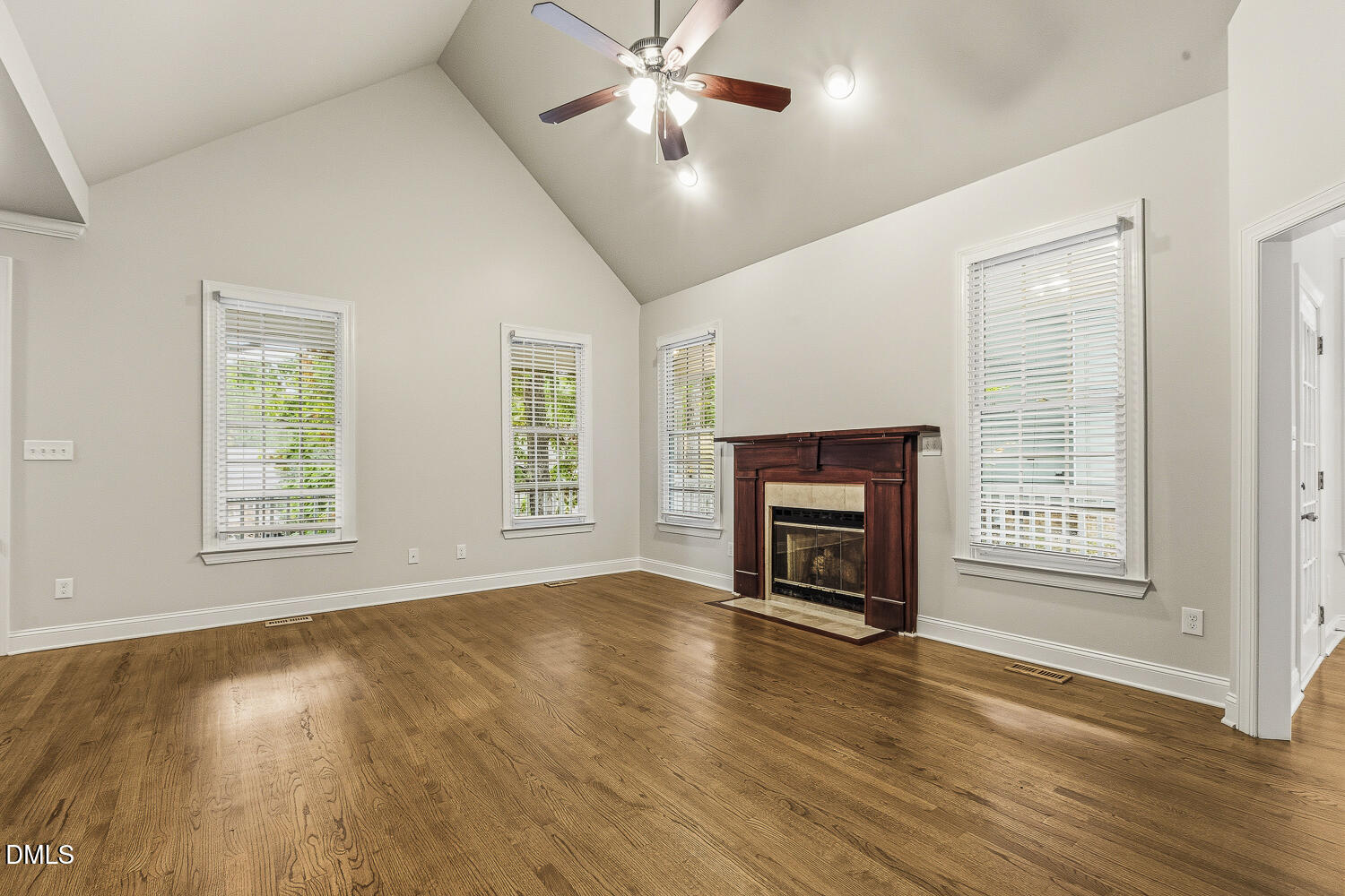 1006 Barnford Mill Road Wake Forest, NC 27587 - Photo 9 of 40 an empty room with windows fireplace and wooden floor