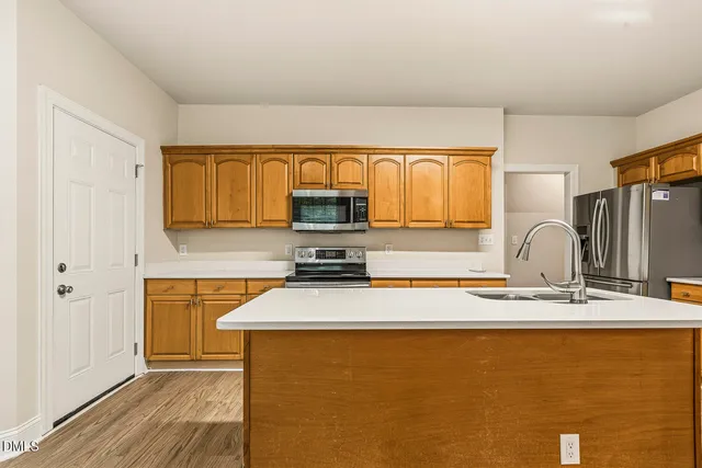 a kitchen with stainless steel appliances granite countertop a sink stove and cabinets