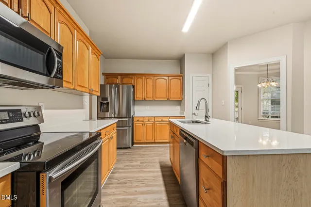 a kitchen with stainless steel appliances granite countertop a stove top oven a sink dishwasher and a refrigerator