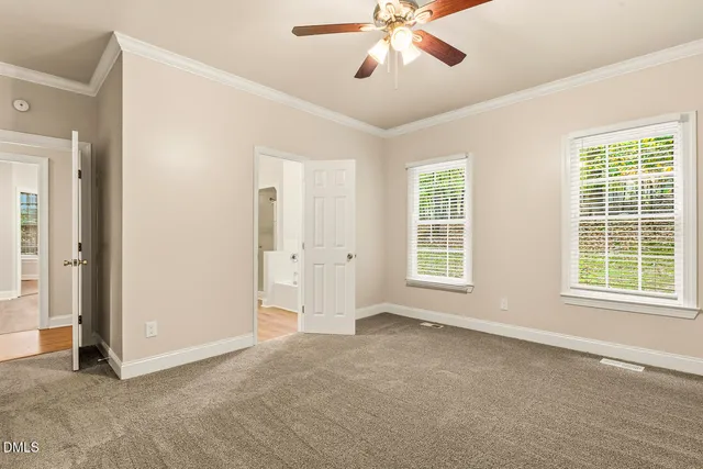 an empty room with windows and fan