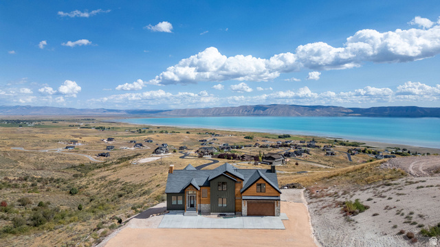 300 Knoll Loop, Unit 227 Fish Haven, ID 83287 - Photo 47 of 56 View of front of house featuring stone siding, a water and mountain view, concrete driveway, and a garage