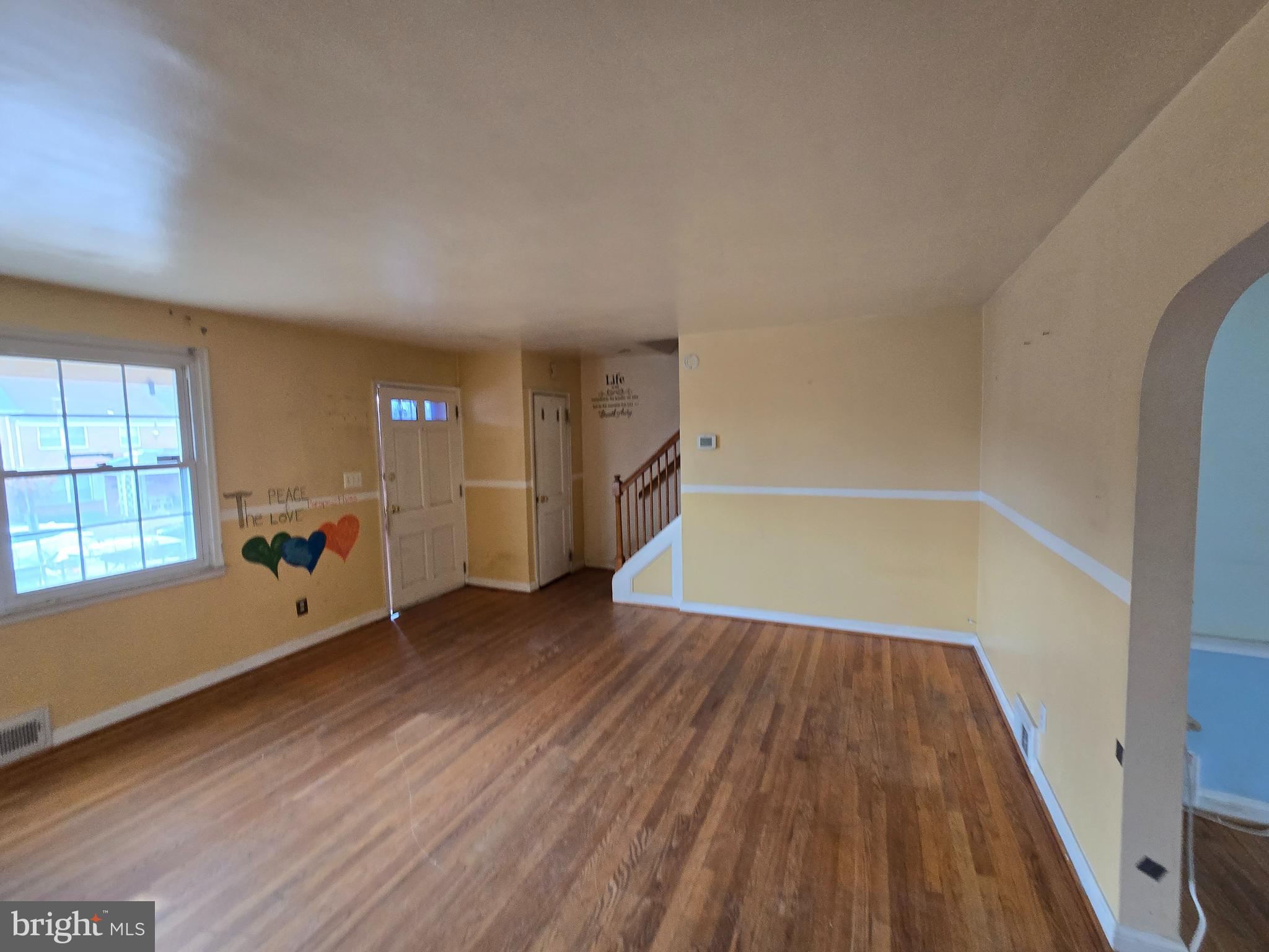 1708 Hartsdale Road Baltimore, MD 21239 - Photo 5 of 26 an empty room with wooden floor and windows